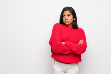 Obraz premium Young Colombian girl with red sweater making doubts gesture while lifting the shoulders