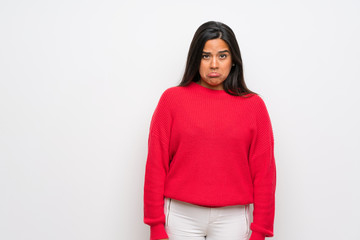 Young Colombian girl with red sweater with sad and depressed expression