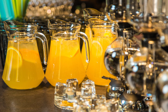 Elegant orange drinks with slices of orange fruit inside big glass bowls. Drinks served on table ready for holiday celebration. Horizontal color photography.