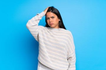 Young Colombian girl with sweater with an expression of frustration and not understanding