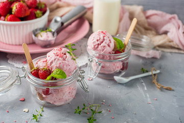 Strawberry ice cream with mint in a glass. Light background