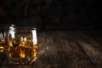 Whiskey in the glasses on dark background.