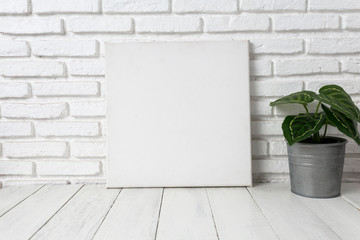 Empty white canvas frame on a wooden table