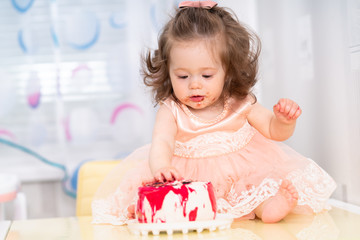 Messy little girl eating a birthday cake