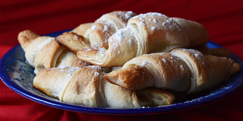 croissants on a blue dish on a red background