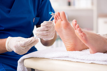 Podiatrist treating feet during procedure