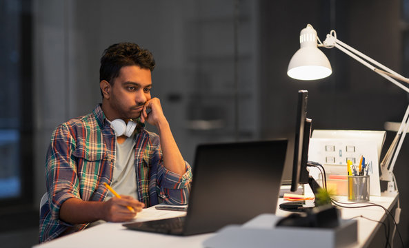 deadline, technology and people concept - creative man with laptop computer working at night office