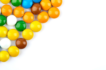 colorful candy on white background. Rainbow sprinkles for topping ice cream and cake. Small candies in colored chocolate glaze.