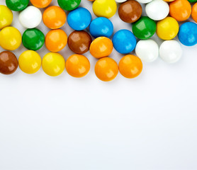 colorful candy on white background. Rainbow sprinkles for topping ice cream and cake. Small candies in colored chocolate glaze.