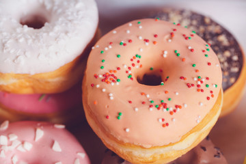Glazed colored donuts background image. Macro shot
