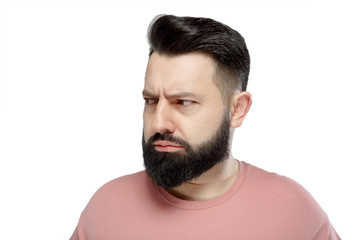 A cute young bearded man in pink shirt shows emotionally happy