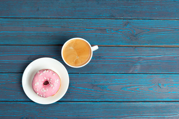 fresh donut with coffee on wooden surface, top view