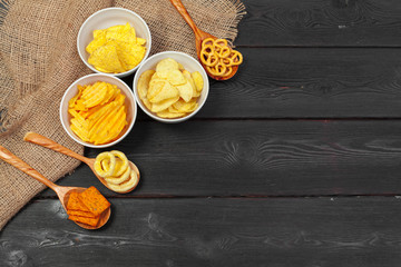 Obraz na płótnie Canvas Mix of snacks : pretzels , crackers , chips and nachos on the table