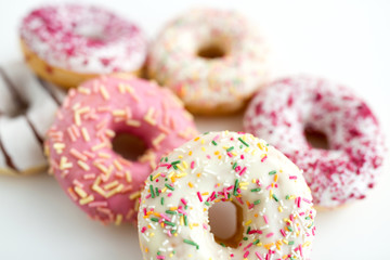sweet food, junk-food and unhealthy eating concept - close up of glazed donuts on white table