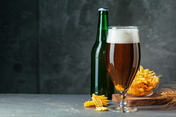 Glass of dark beer with bowl of beer snacks close up