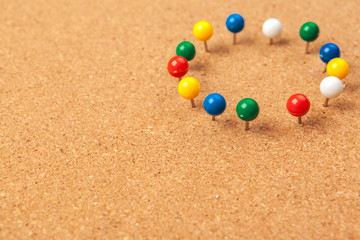 Group of thumbtacks pinned on corkboard