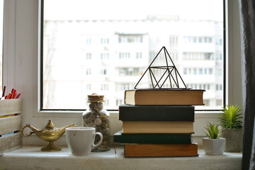 Stack of books lying on the windowsill. Knowledge and reading background.
