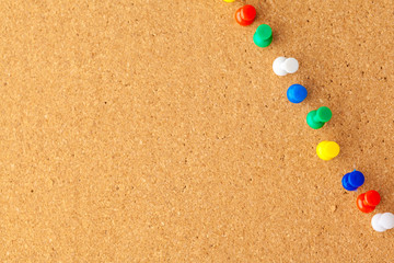 Group of thumbtacks pinned on corkboard