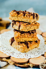 Organic homemade granola bars with salt date caramel and chocolate on blue background.Selective focus.