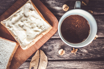 Bread and coffee on wooden background