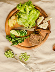 Ingredients for green salad with a piece of bread. Make a fresh salad of avocado, greens, peas, parsley, cabbage, cucumber and apples.Vegetables on a wooden board. Top view.