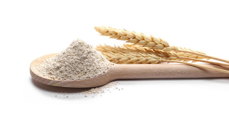 Integral barley flour and wheat ears with wooden spoon isolated on white background