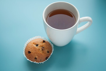 Tea with muffins with chocolate drops. Delicious sweet dessert. Sweetness to tea. Homemade baking. Treats for children. Popular cupcake.