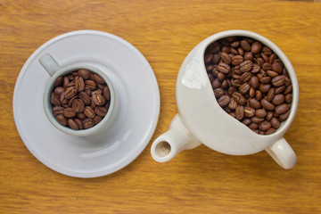 cup and teapot with coffee beans