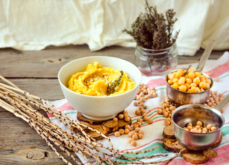 Healthy Homemade Hummus with turmeric and rosemary on a rustic wooden table.Selective focus.