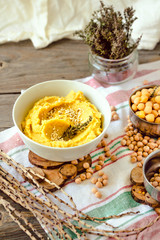 Healthy Homemade Hummus with turmeric and rosemary on a rustic wooden table.Selective focus.