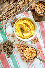 Classic Chickpea hummus in white bowl on wooden rustic background.Top view