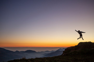 Silueta de una persona saltando sobre una puesta de sol