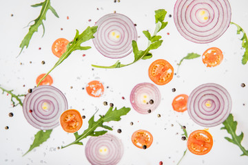 background with sliced tomatoes, red onions, arugula leaves and spices