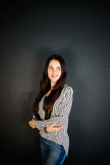 Stylish girl in a shirt posing on a dark background