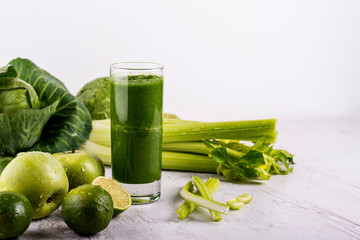 Blended green smoothie with ingredients on wooden table. Dexox drink