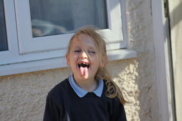 portrait of a little girl with tounge out
