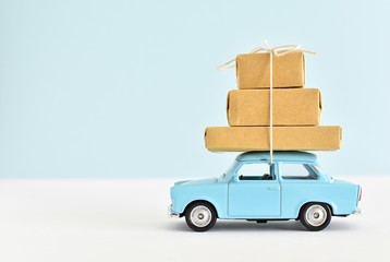 Moving, delivery, shopping, sale concept, blue retro car with packages on the roof.