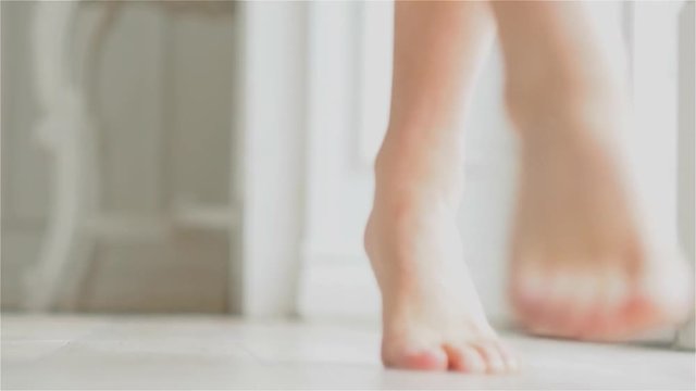 Women's bare feet, body parts. Young barefoot woman enters frame