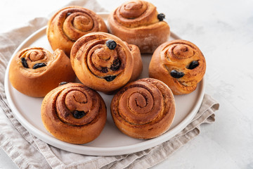 Freshly Baked Traditional Sweet Cinnamon Rolls, Swirl on white plate. Copy space.