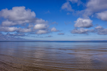 light fluffy clouds over the calm sea