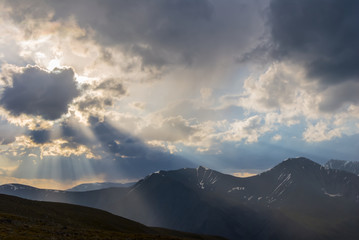 mountain chain silhouette under a dense cloudy sky