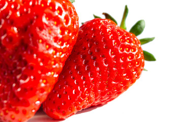 two bright juicy strawberries on a white background, macro