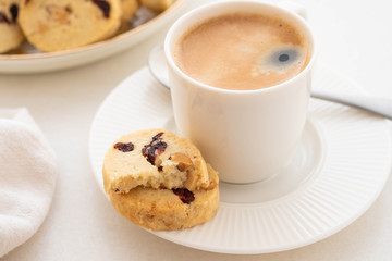 A cup of coffee with homemade cookies on a white background.