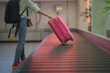 luggage reclaim at the airport in the transfer belt by woman traveler at the last stage of final...