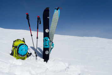 Splitboard halves, trekking sticks and backpack at sky background with copy-space. Ski touring...