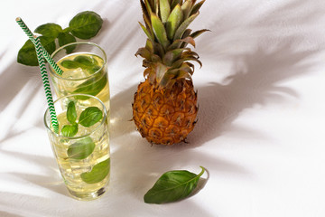 Pineapple juice with palm leaves on white