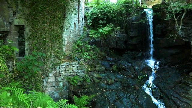 Waterfall and stone ruins of the 17th century mill. Lumsdale, Derbyshire, England.