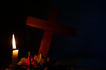 Giving respect to human soul. Give a candle and rose under Jesus cross in cemetery on moonlight.