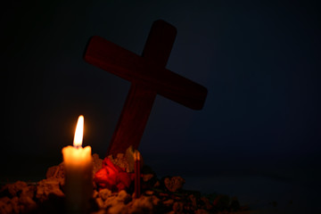 Giving respect to human soul. Give a candle and rose under Jesus cross in cemetery on moonlight.