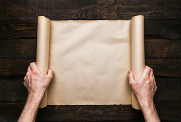 Male hands holding old paper scroll
